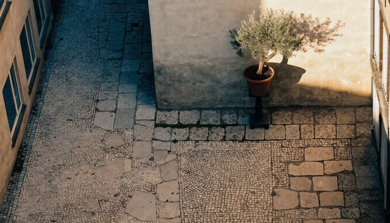 Ruhiger Münchner Innenhof am späten Nachmittag mit Steinpflaster und Schatten